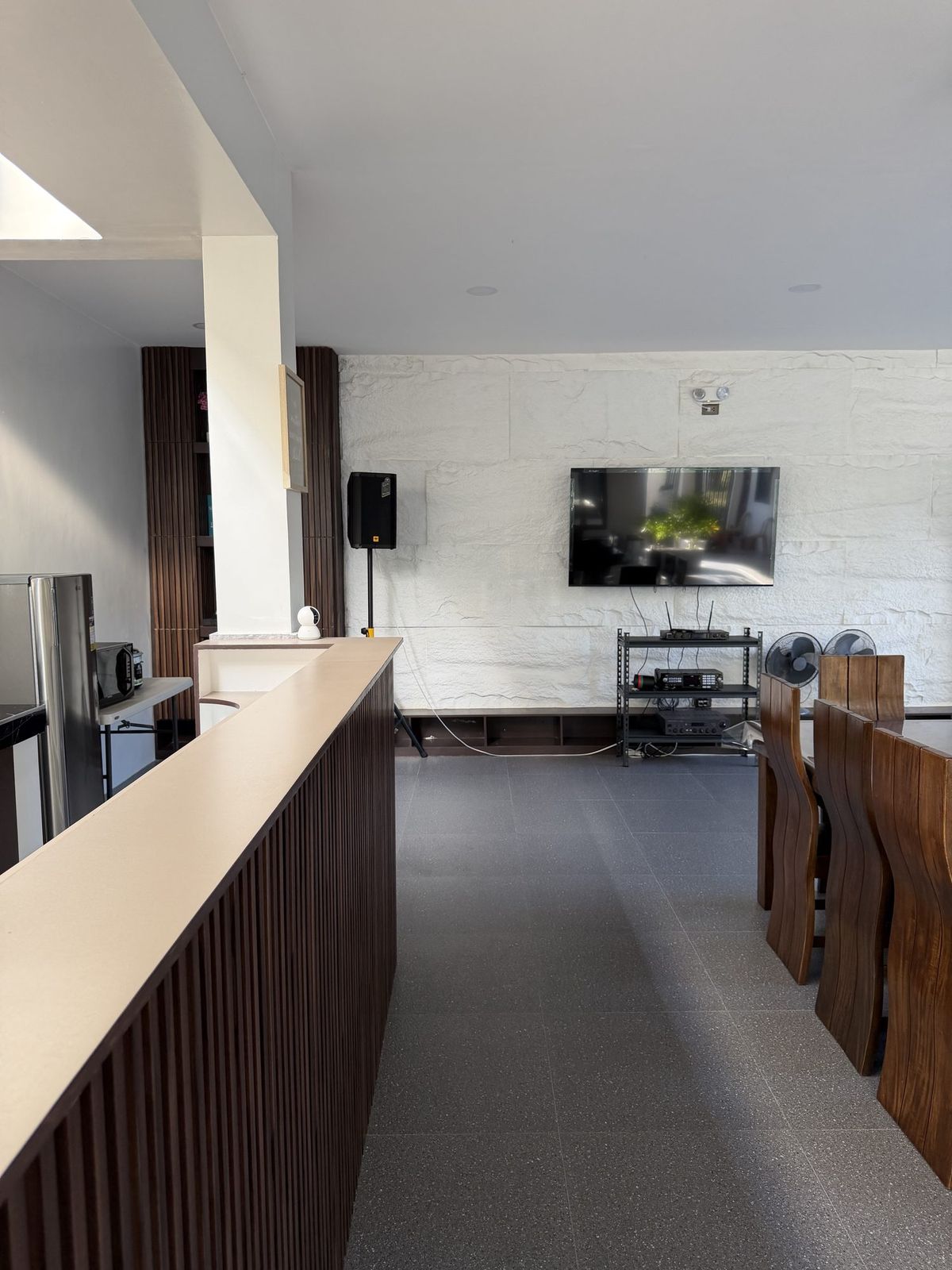 The bar counter with a wall-mounted television and speakers above it