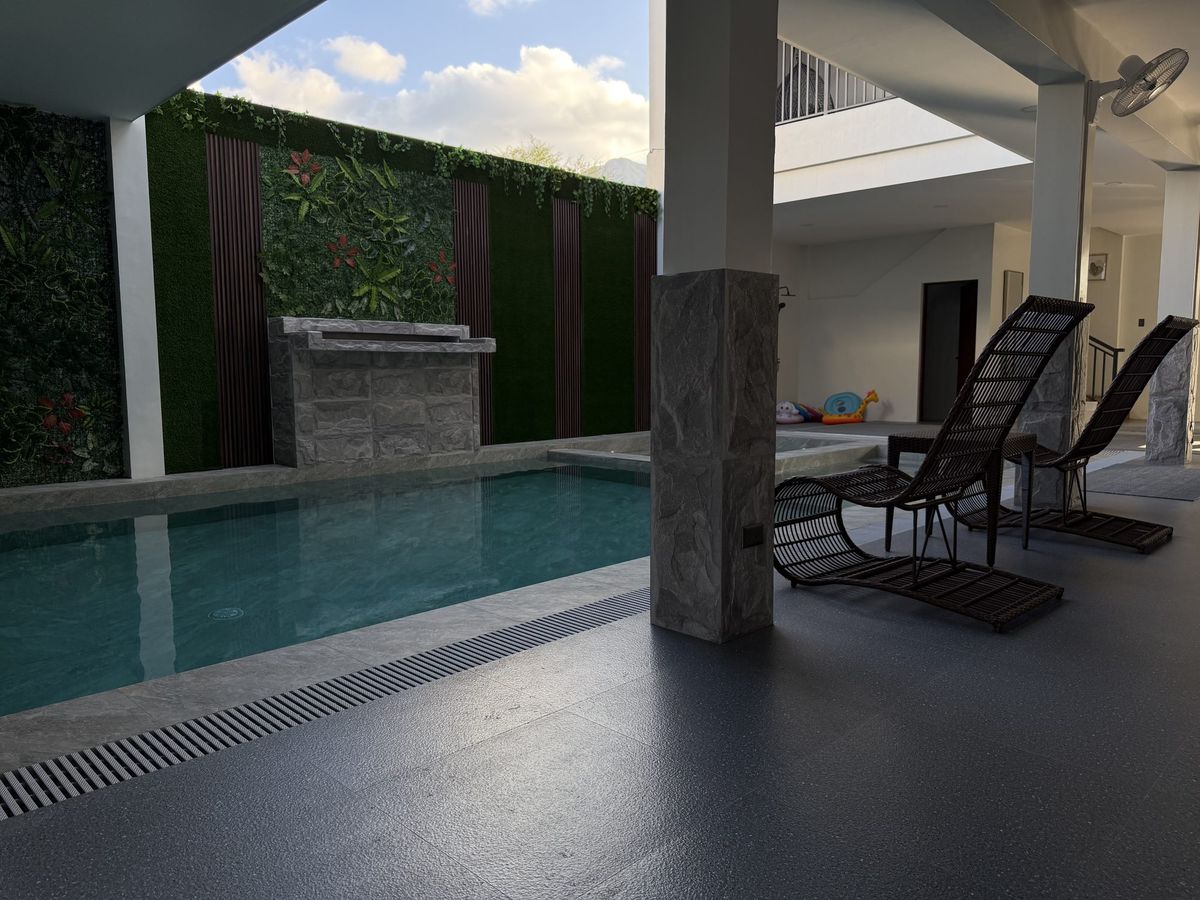 Two sun loungers set out beside the open pool in the afternoon